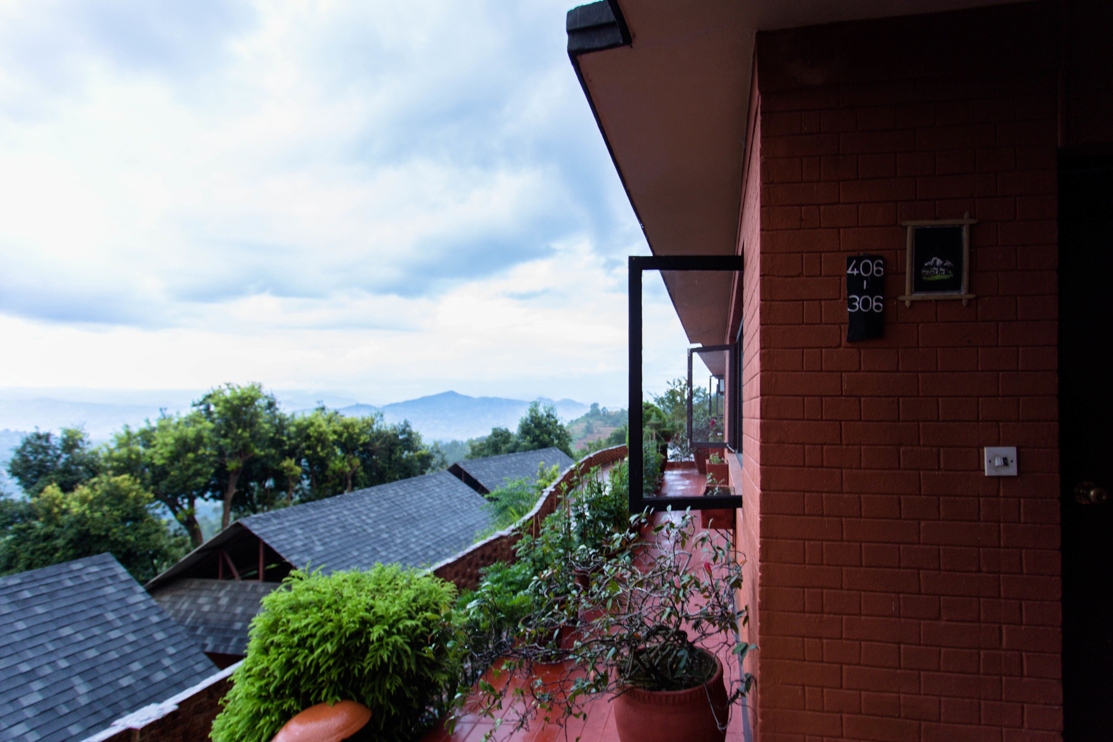 A balcony with a view of neighboring houses and mountains.