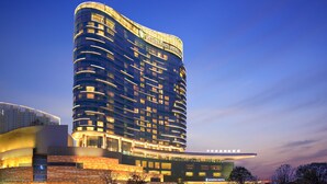 A modern hotel with a curved facade, multiple balconies, and illuminated signage. - InterContinental Changsha by IHG (Changsha)