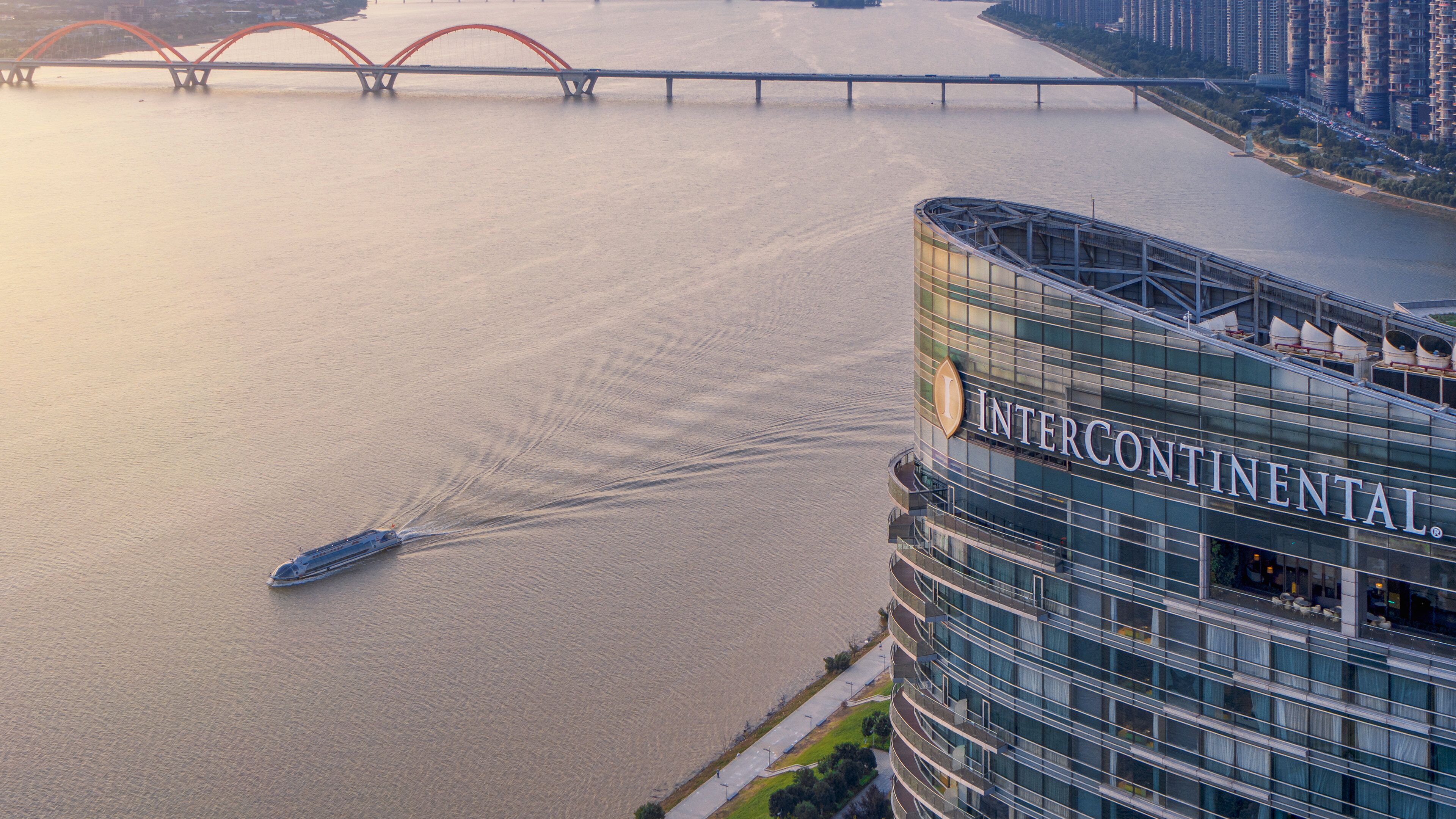 A modern hotel with a view of a river and a bridge.