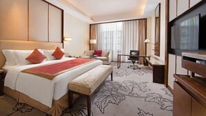 A hotel room with a large bed, a desk, a chair, a television, and a sofa. - Luxury Blue Horizon Hotel (Hot Spring Hotel) (Dongying)