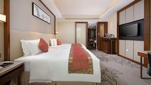 A hotel room with a large bed, a TV, a desk, and a bathroom visible through an open door. - Luxury Blue Horizon Hotel (Hot Spring Hotel) (Dongying)