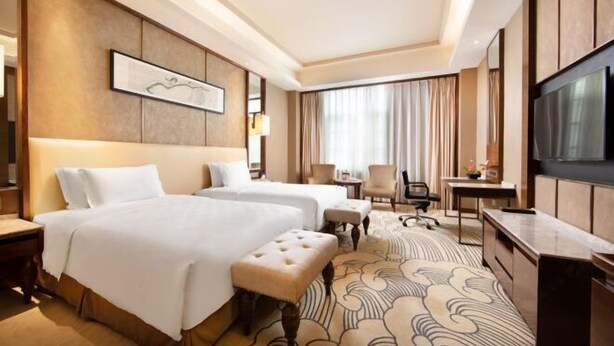 A hotel room with two beds, a desk, a TV, and a large window with curtains. - Luxury Blue Horizon Hotel (Hot Spring Hotel) (Dongying)