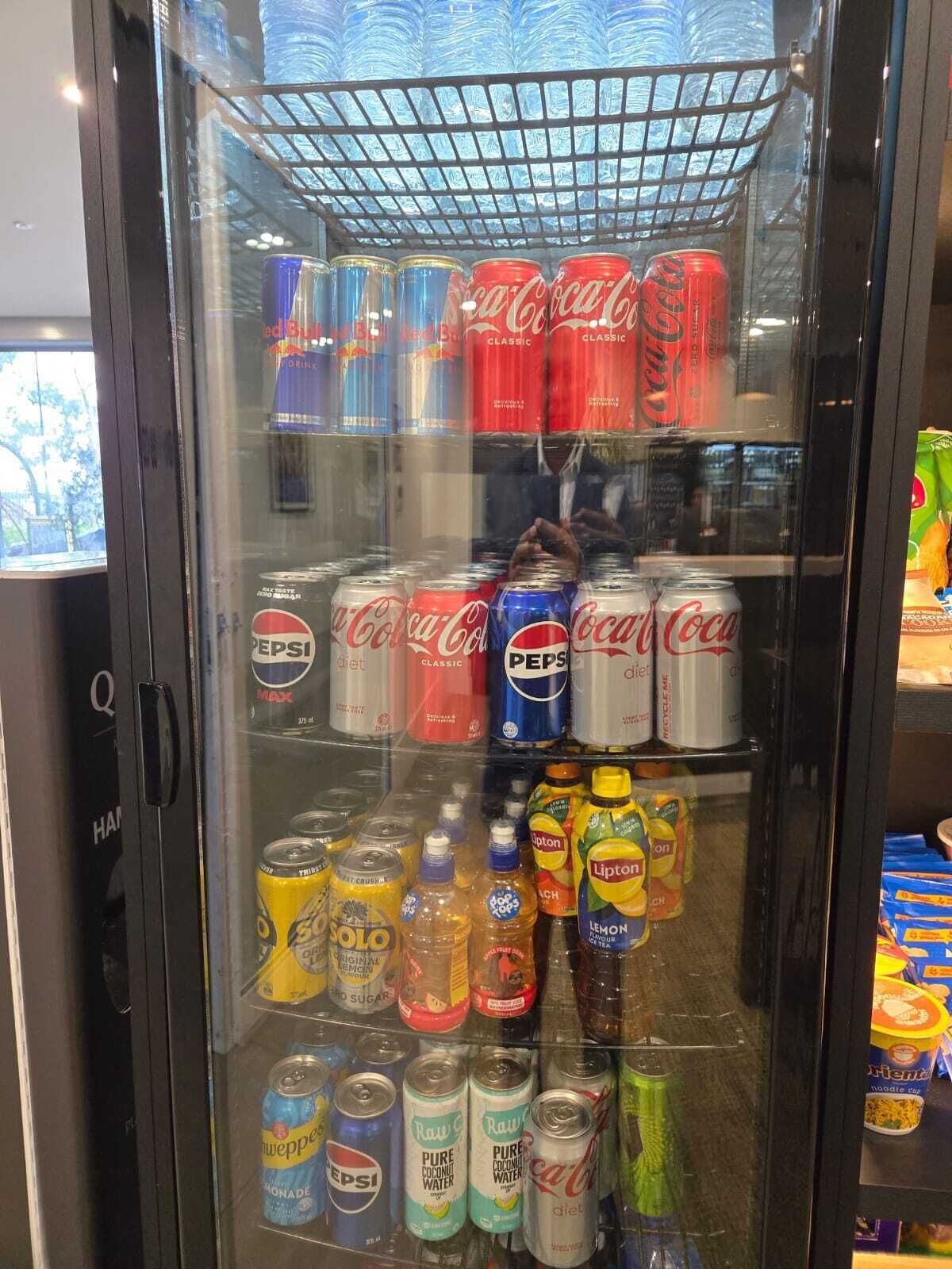 Máquina expendedora de bebidas con Coca-Cola, Pepsi y té Lipton.