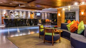 Eine moderne Lobby mit Empfangstresen, Sitzgelegenheiten und einem Fernsehbildschirm.
