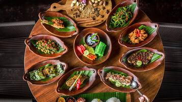 A wooden tray with various dishes, including rice and vegetables, arranged on a table.