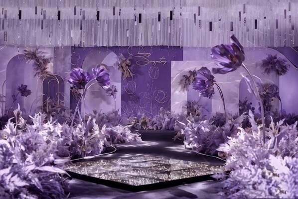 A room with a central pathway, floral arrangements, and a decorative backdrop.