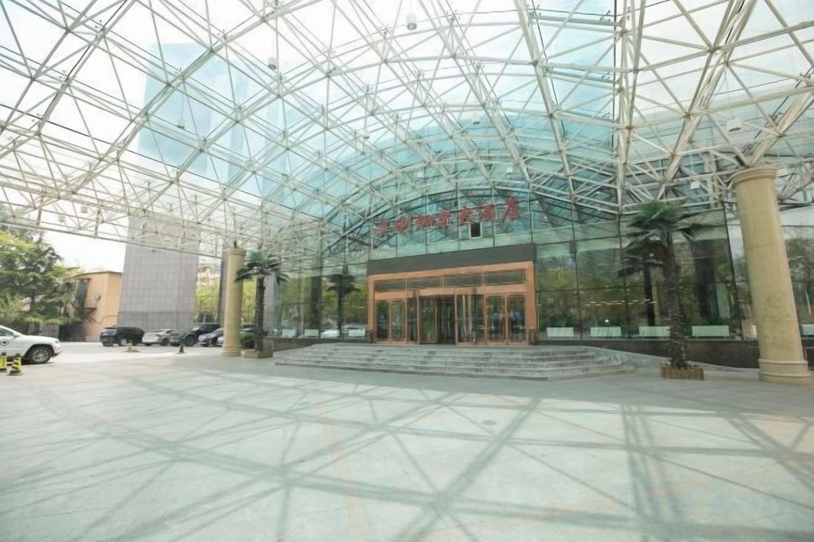 A modern building with a glass facade and a geometric metal framework.