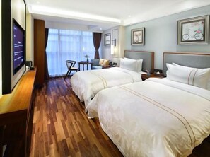 A hotel room with two beds, a TV, a desk, and a view of the outdoors. - Andersen Culture (Shanghai)