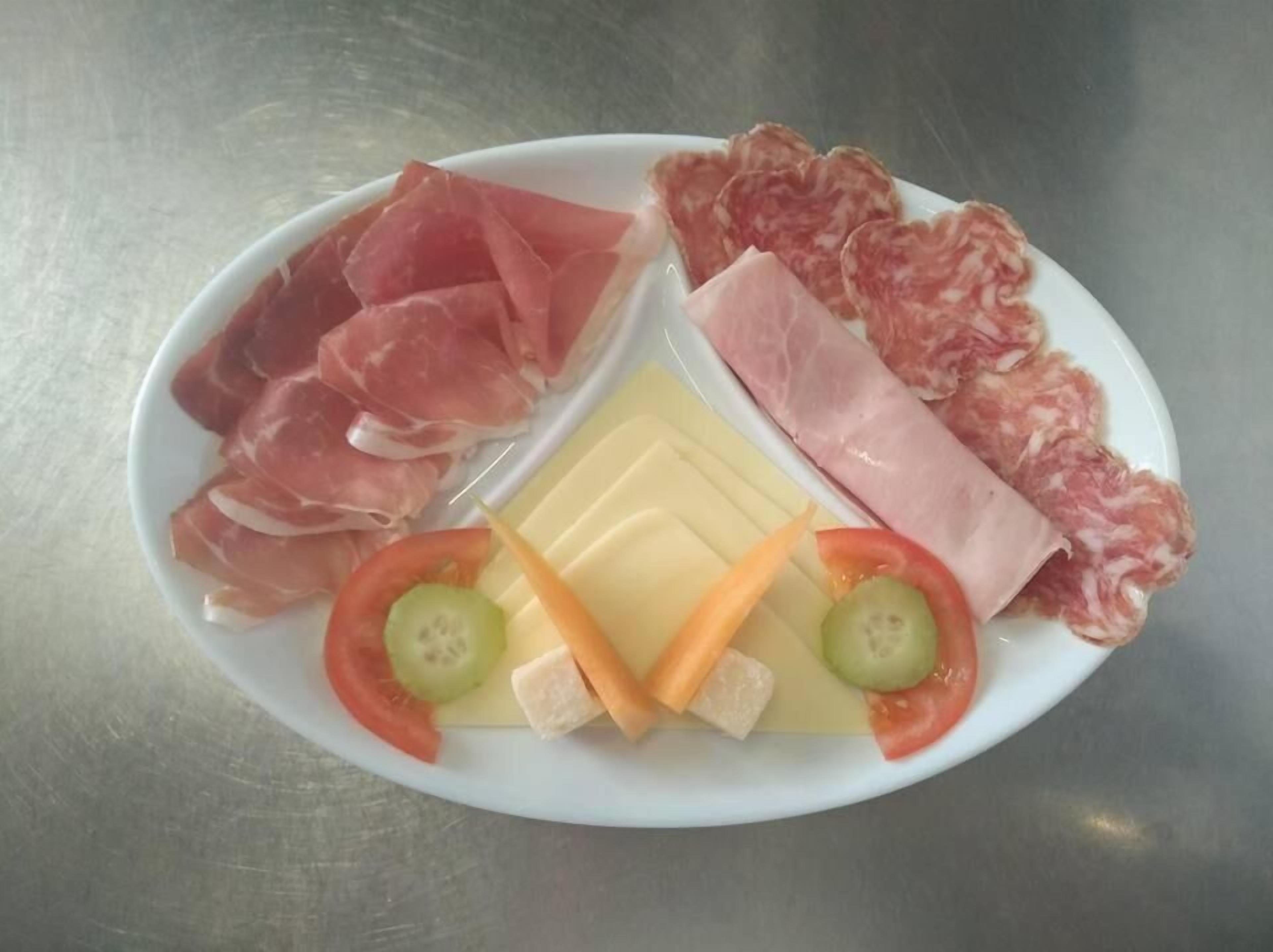 A plate with various meats, cheese, and vegetables.