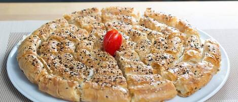 Un pastelito redondo con semillas de sésamo sobre un plato blanco.