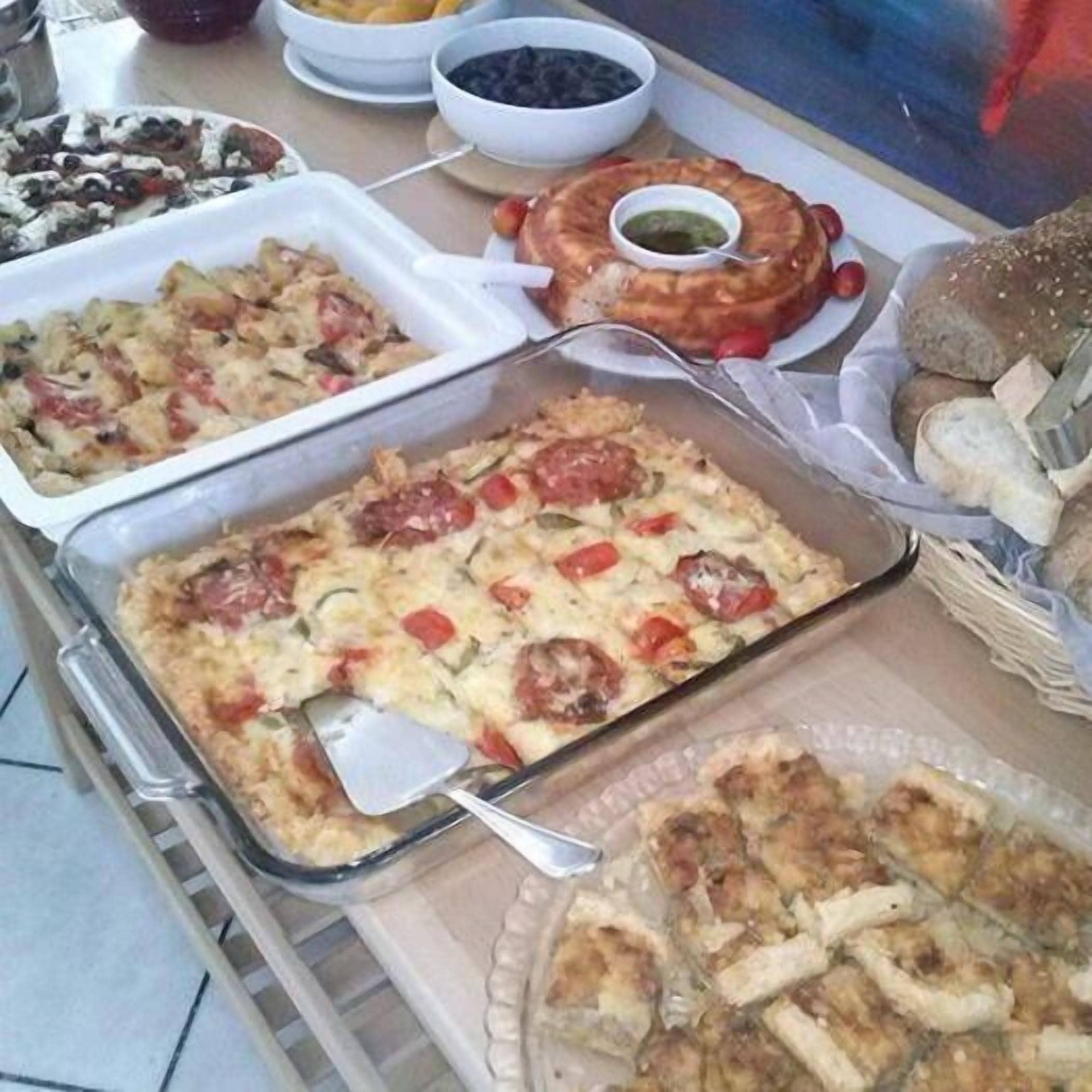 A buffet table with various dishes including casseroles, bread, and dips.