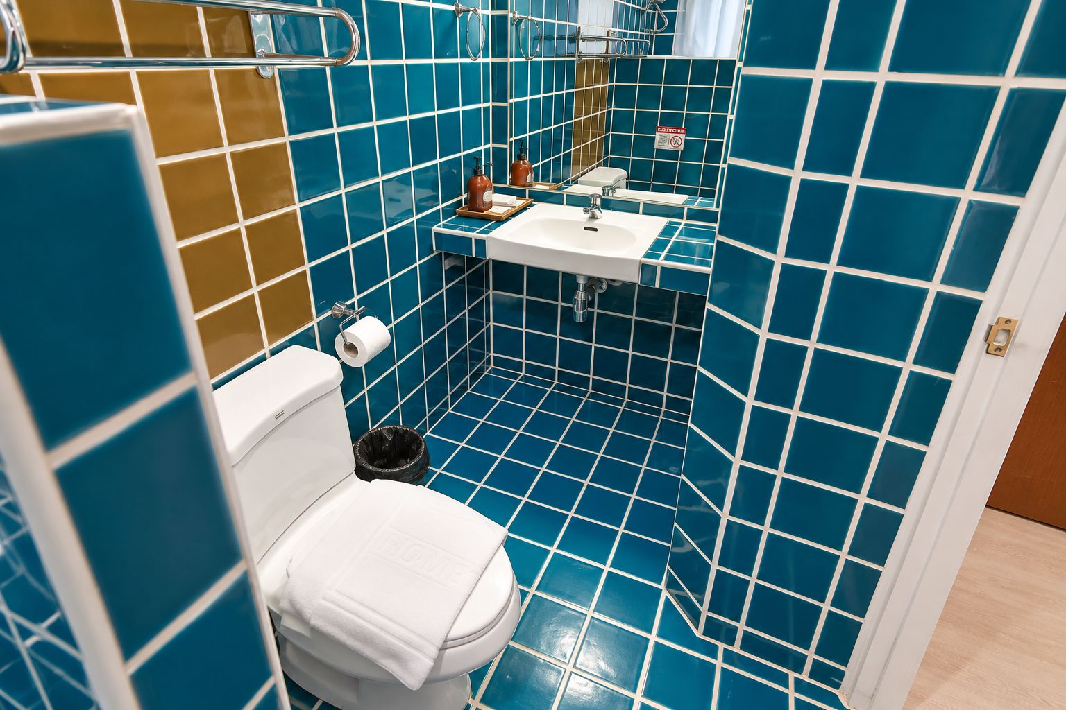 A bathroom with a toilet, sink, and mirror.