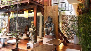 Un intérieur de style japonais traditionnel, avec un sol recouvert de tatamis, de basses tables en bois et diverses statues.