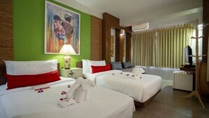 Une chambre d’hôtel avec deux lits, un mur d’accent de couleur verte, un tableau, une lampe et un téléviseur.