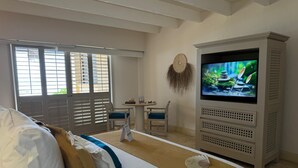 Una habitación de hotel con una cama, televisión, escritorio y una silla.