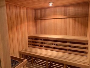 Una sauna de madera con bancos y una luz en el techo.
