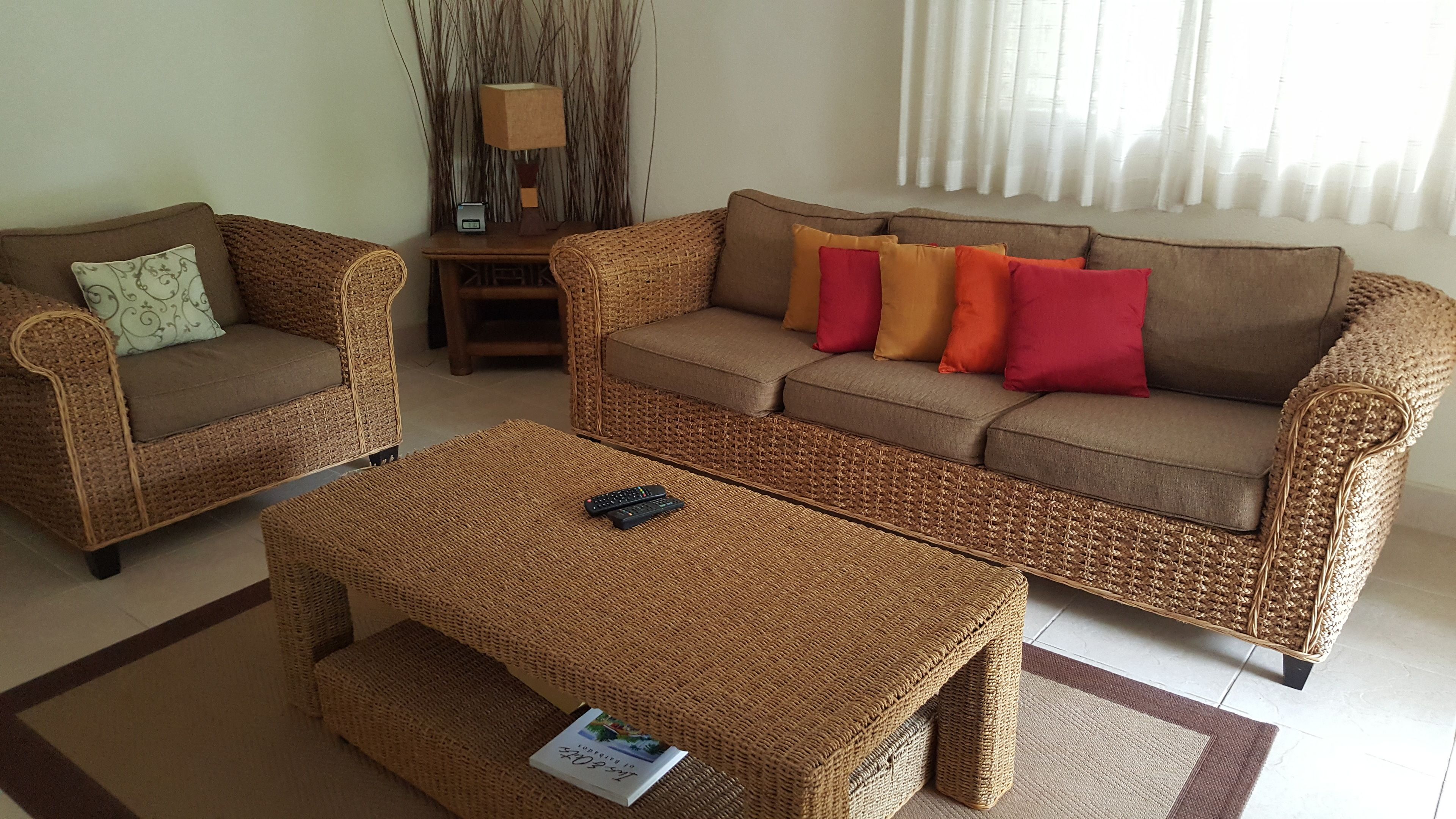 A living room with a brown woven sofa, a matching armchair, and a coffee table.