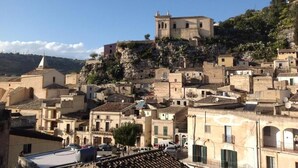Une ville pittoresque située sur une colline, avec des bâtiments historiques, dont une église imposante qui se dresse au sommet.