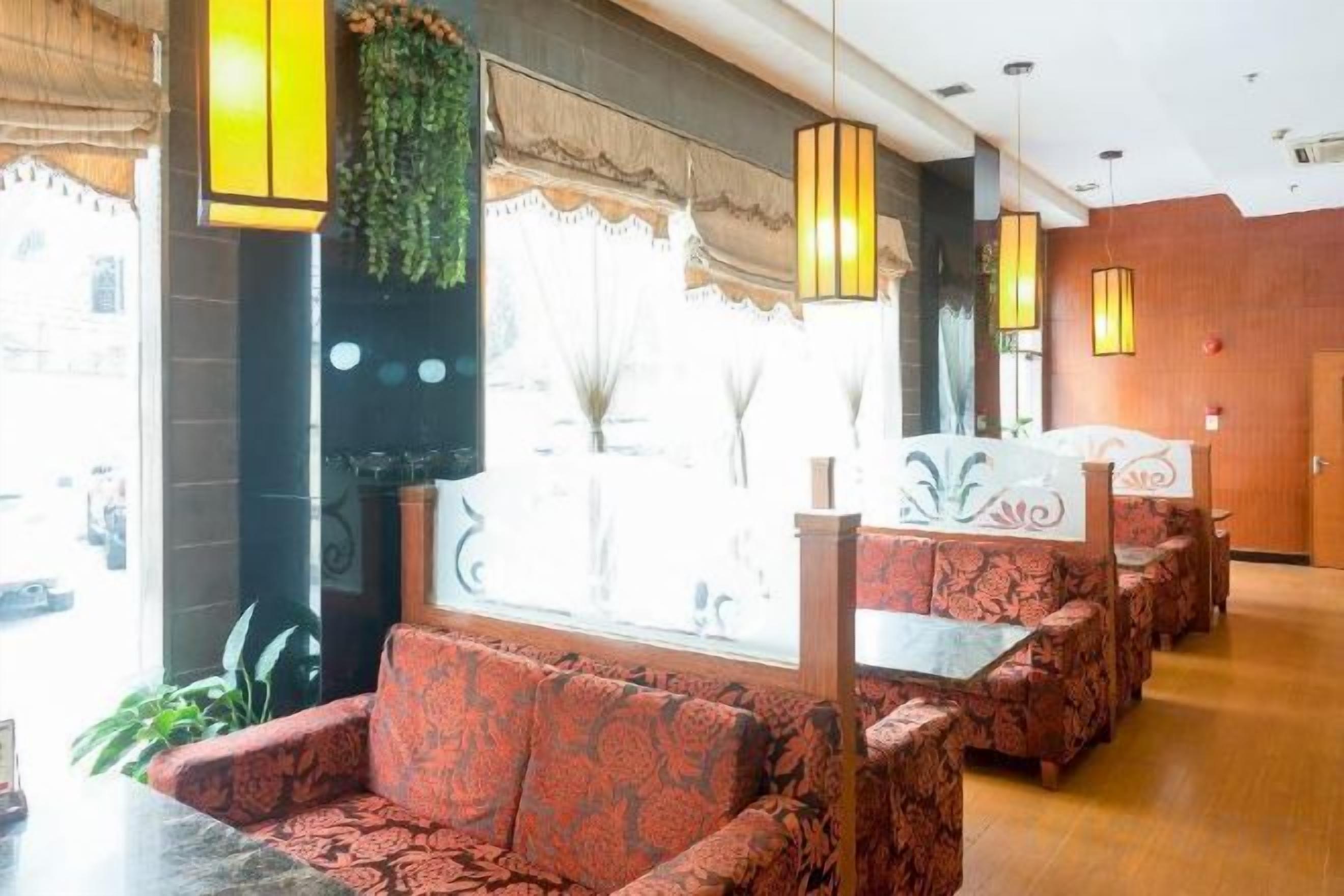 A hotel lobby with a seating area featuring patterned sofas and a decorative wall.