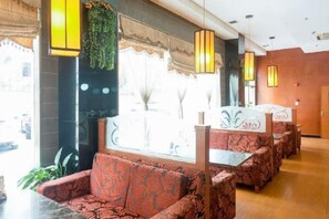 A hotel lobby with a seating area featuring patterned sofas and a decorative wall. - Meiyutu International Hotel (Shenzhen Bao'an Branch) (Shenzhen)