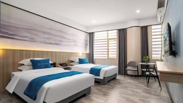 A modern hotel room with two beds, a desk, and a chair. - Meiyutu International Hotel (Shenzhen Bao'an Branch) (Shenzhen)