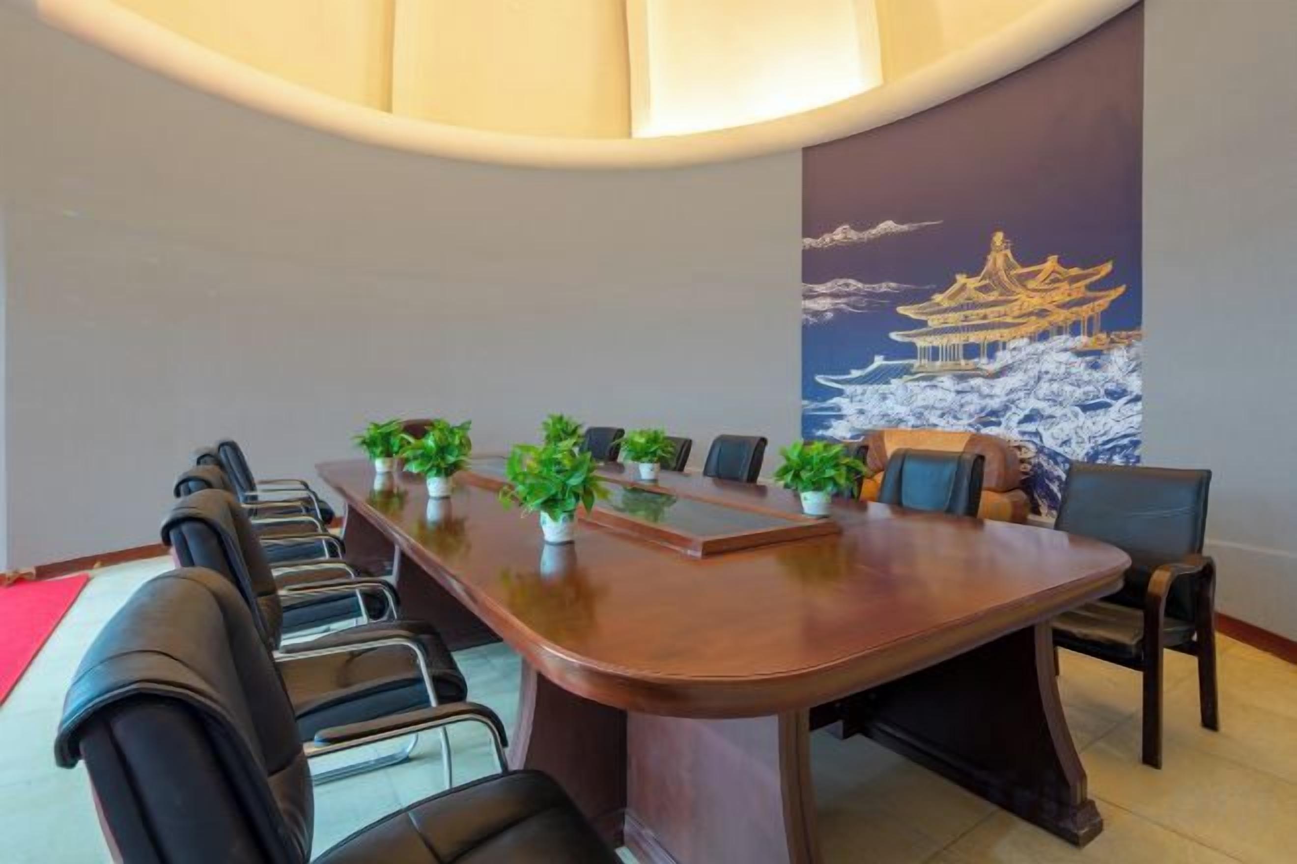 A conference room with a long table, chairs, and potted plants.