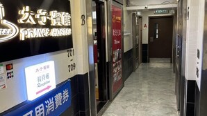 A hotel corridor with a reception desk, a sign for Prince Hotel, and a reception area. - Prince Hotel (Kowloon)