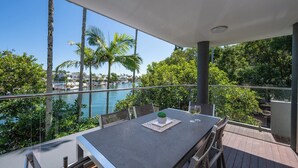 A balcony with a table, chairs, and a potted plant. - 2 Hastings Street (Noosa Heads)