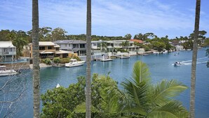 A marina with boats docked, surrounded by residential buildings and palm trees. - 2 Hastings Street (Noosa Heads)