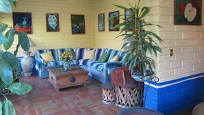 Un salón acogedor con un sofá a rayas azules, una mesa de centro de madera y una planta en maceta.