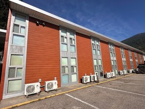 A building with multiple air conditioning units and large windows.