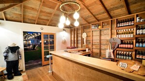 A rustic bar area with wooden beams, a counter with wine bottles, and a plush dog statue. - Alamo Motel (Los Alamos)