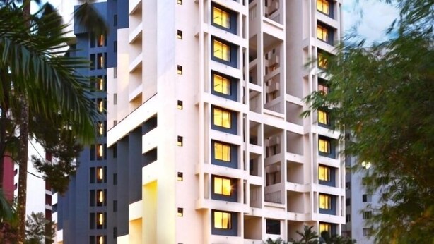 A multi-story hotel with a modern architectural design, featuring balconies and large windows. - Riviera Suites (Kanayannur)