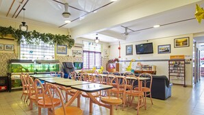 Un restaurante con varias mesas y sillas, acuarios y una zona de juegos para niños.