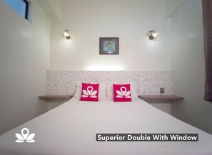 A Superior Double With Window room featuring a bed with two pillows, a framed picture on the wall, and two wall-mounted lights. - Coastal Park Hotel (Malacca City)