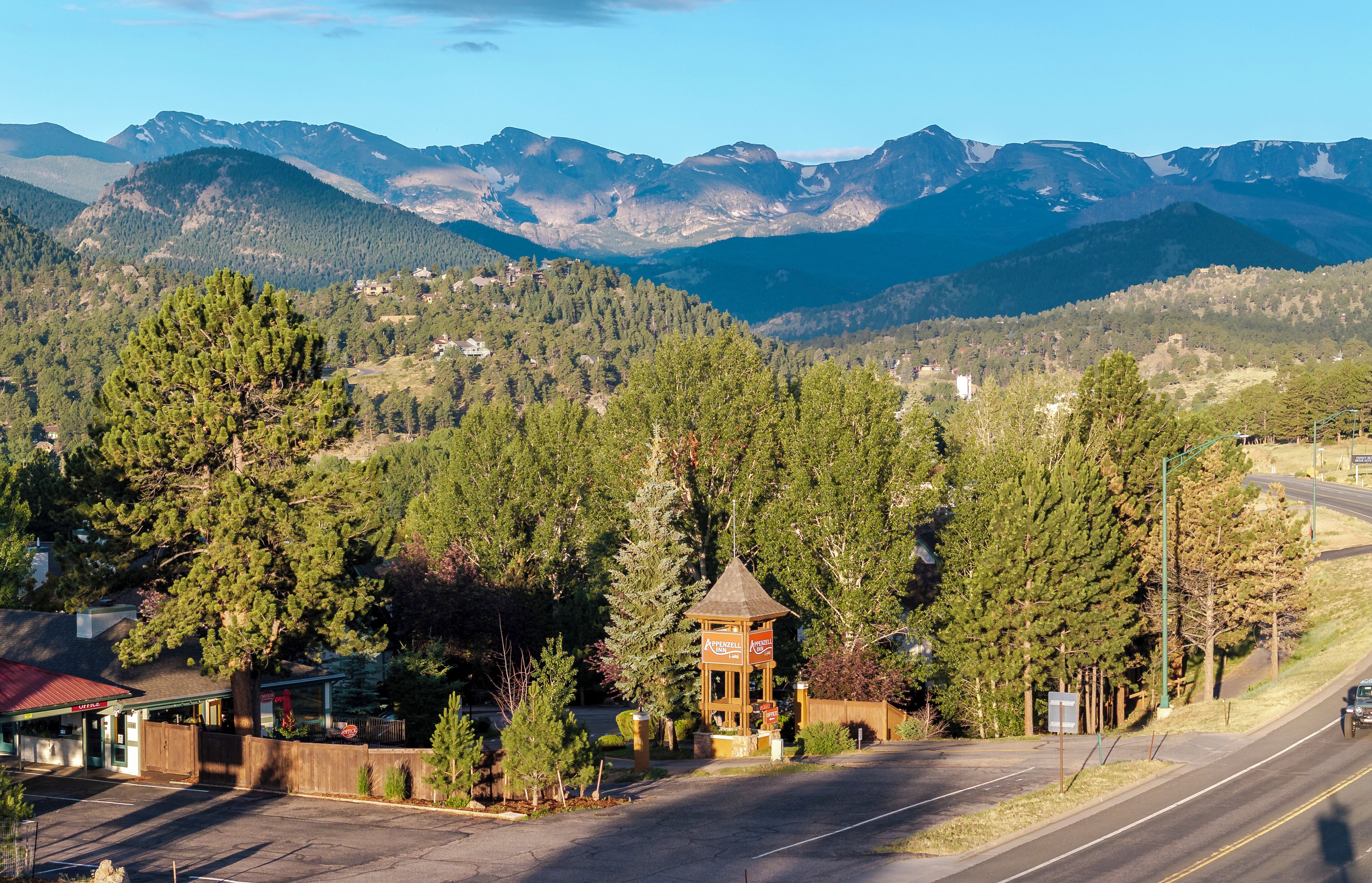 A mountain town with a gazebo, a road, and a view of the surrounding mountains.