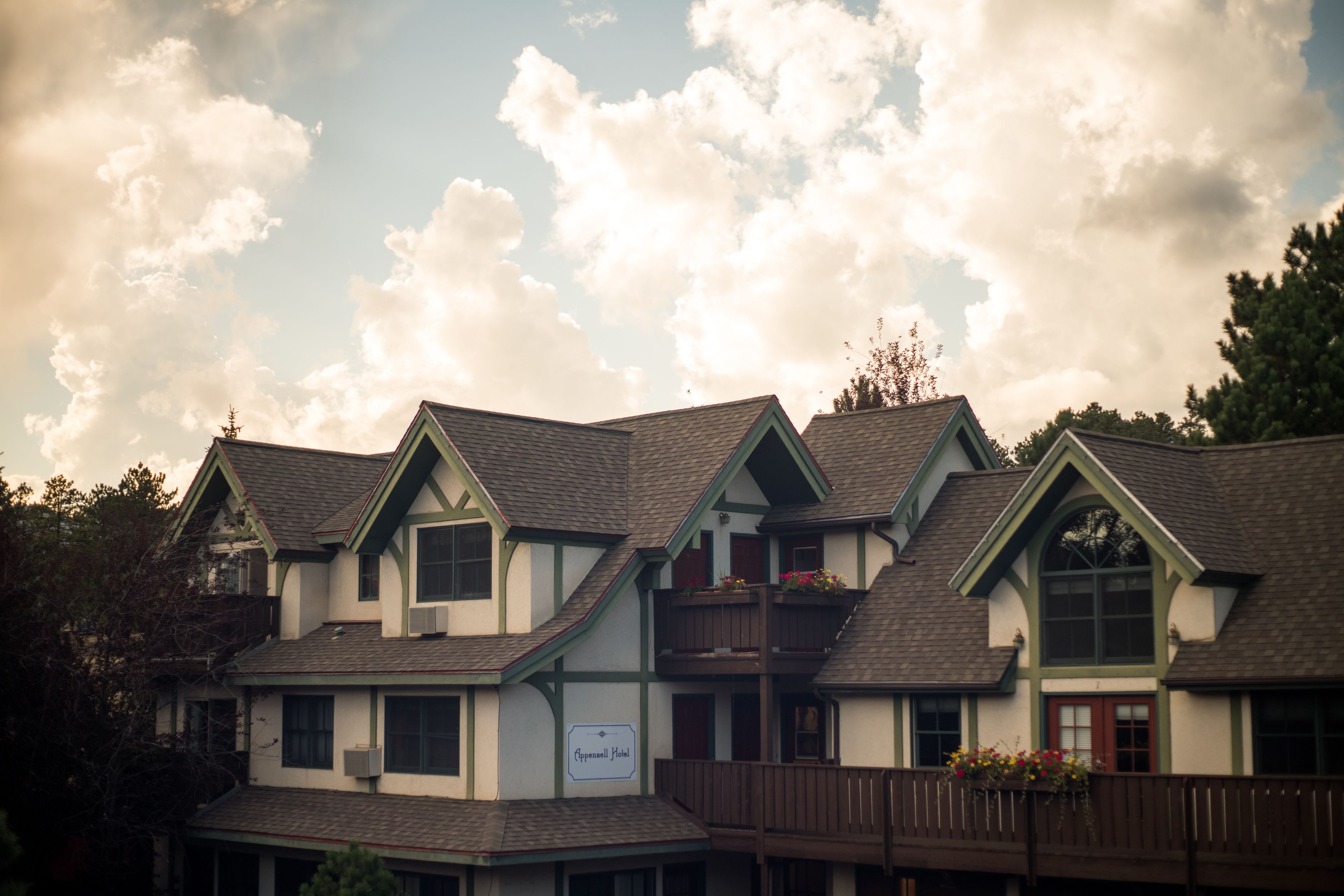 A row of multi-story buildings with a traditional architectural style, featuring gabled roofs and a mix of dormer windows.