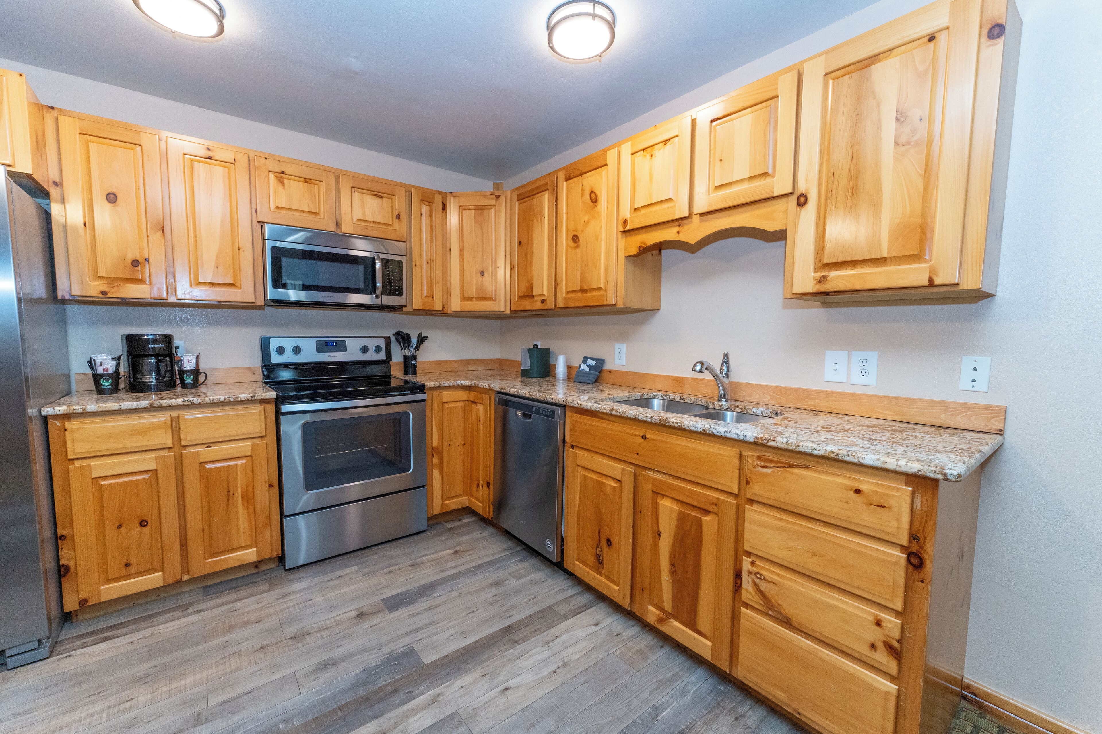 A kitchen with wooden cabinets, stainless steel appliances, and a granite countertop.
