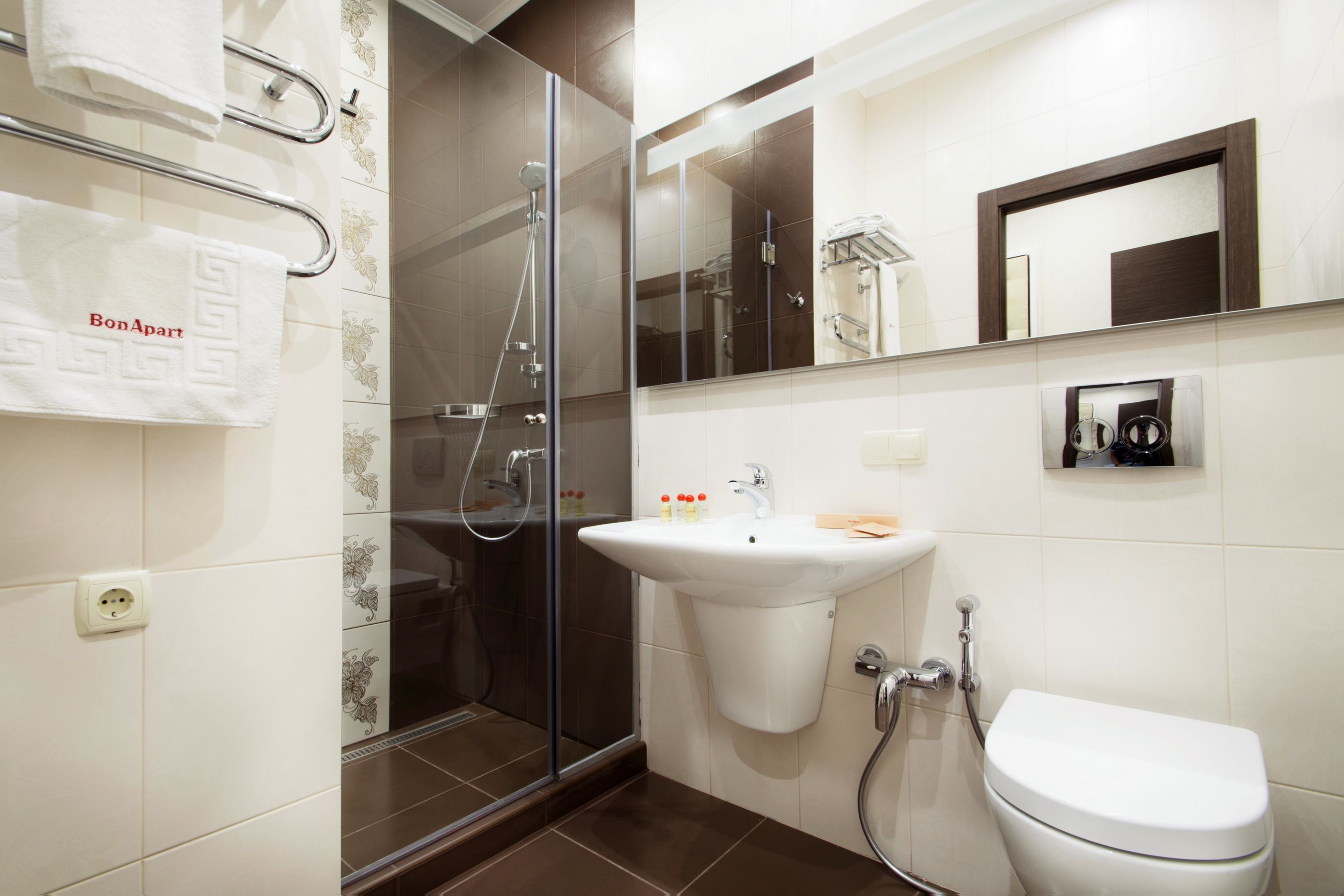 A modern bathroom with a glass-enclosed shower, a white sink, and a toilet.