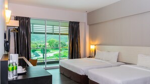 Une chambre d’hôtel avec deux lits, un bureau et une vue sur un paysage verdoyant.
