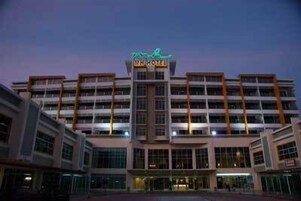 Un hotel de varios pisos con un letrero llamativo en la parte superior.