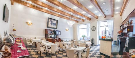 Comedor con piso a cuadros, vigas de madera y mesas dispuestas para una comida.