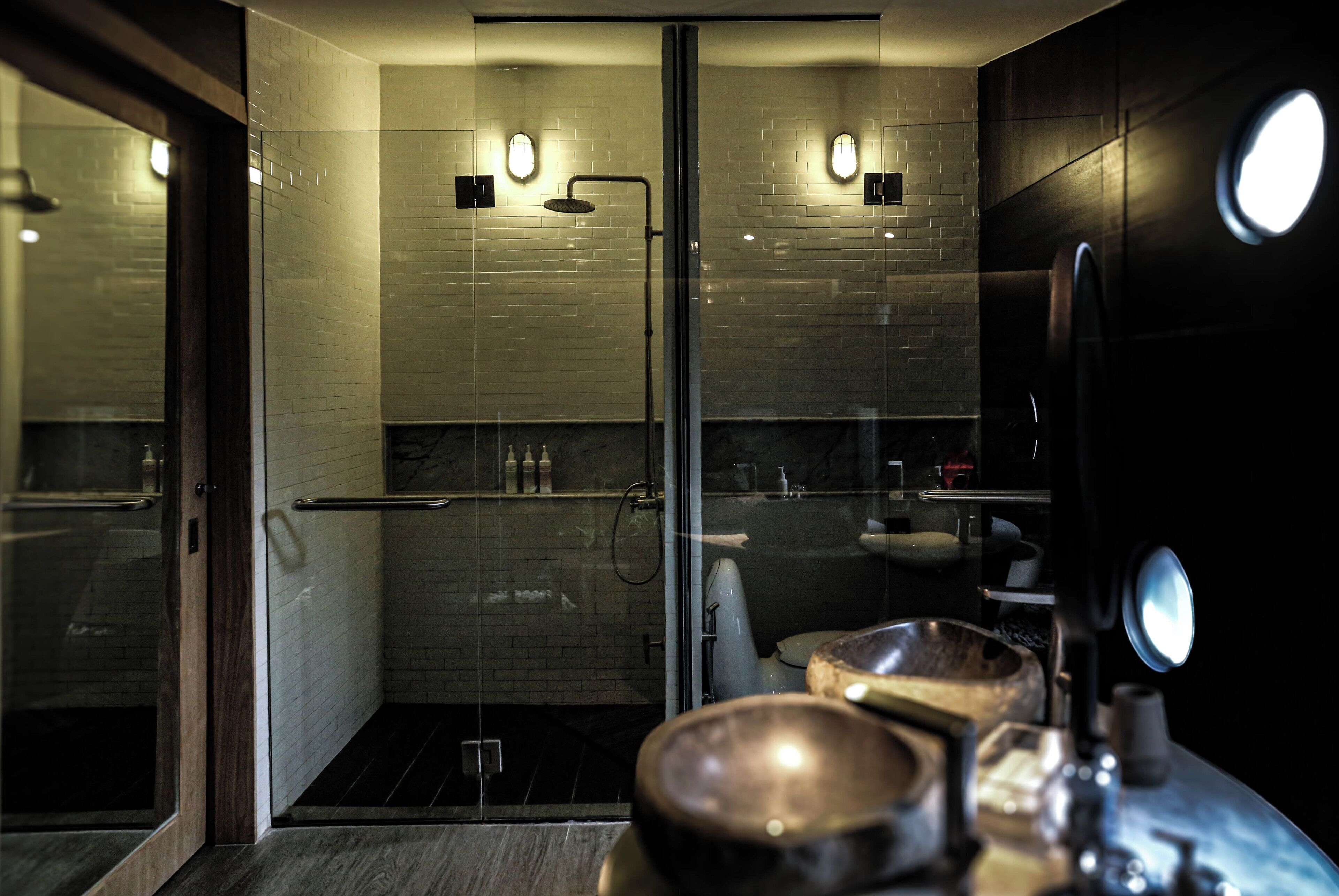 Une salle de bain moderne avec une douche à parois de verre, un meuble-lavabo en bois et un grand miroir.