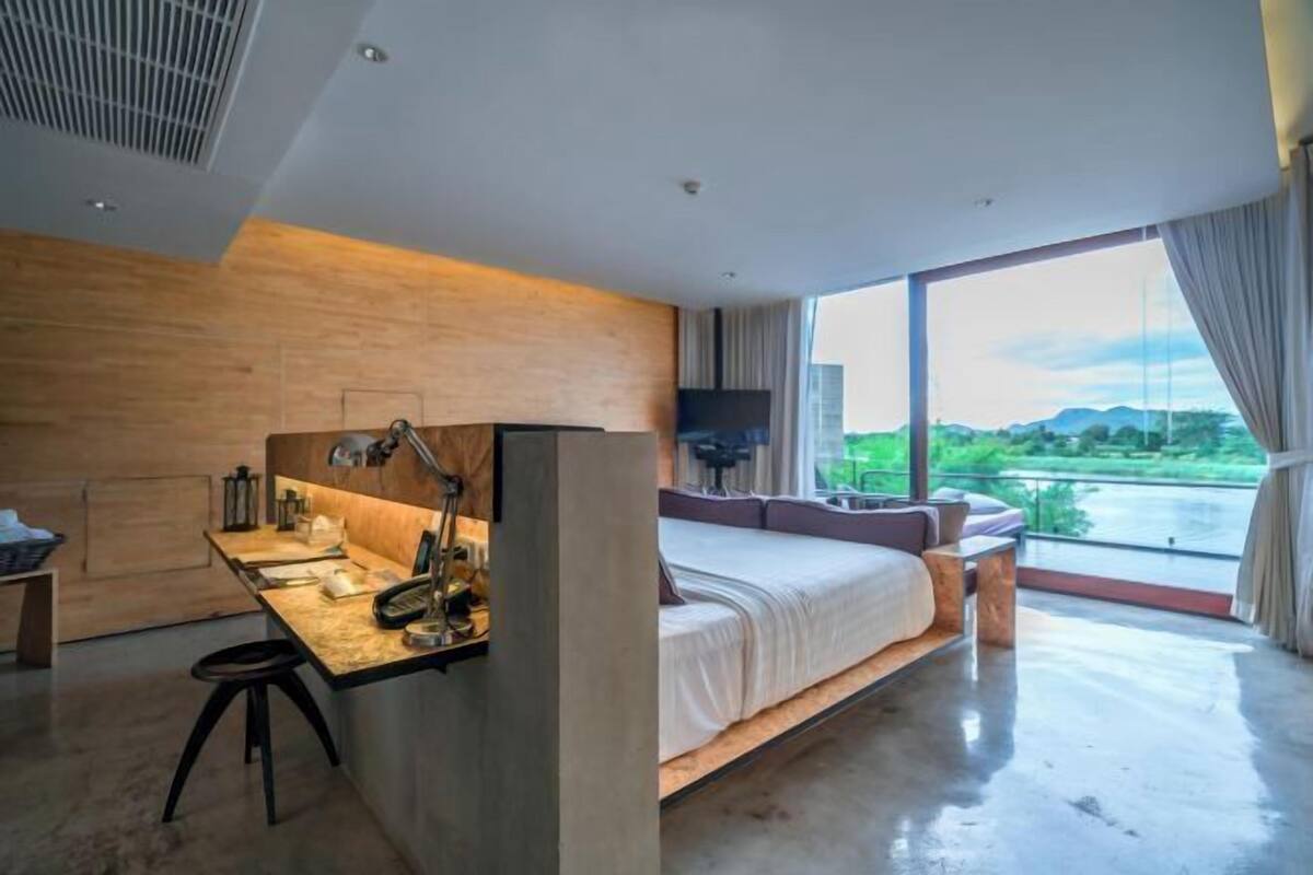 Ein modernes Schlafzimmer mit einem großen Bett, einem Schreibtisch und einem Fernseher.