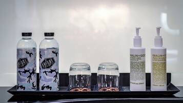 A tray with two bottles of water, two bottles of hand wash soap, and two bottles of body wash.
