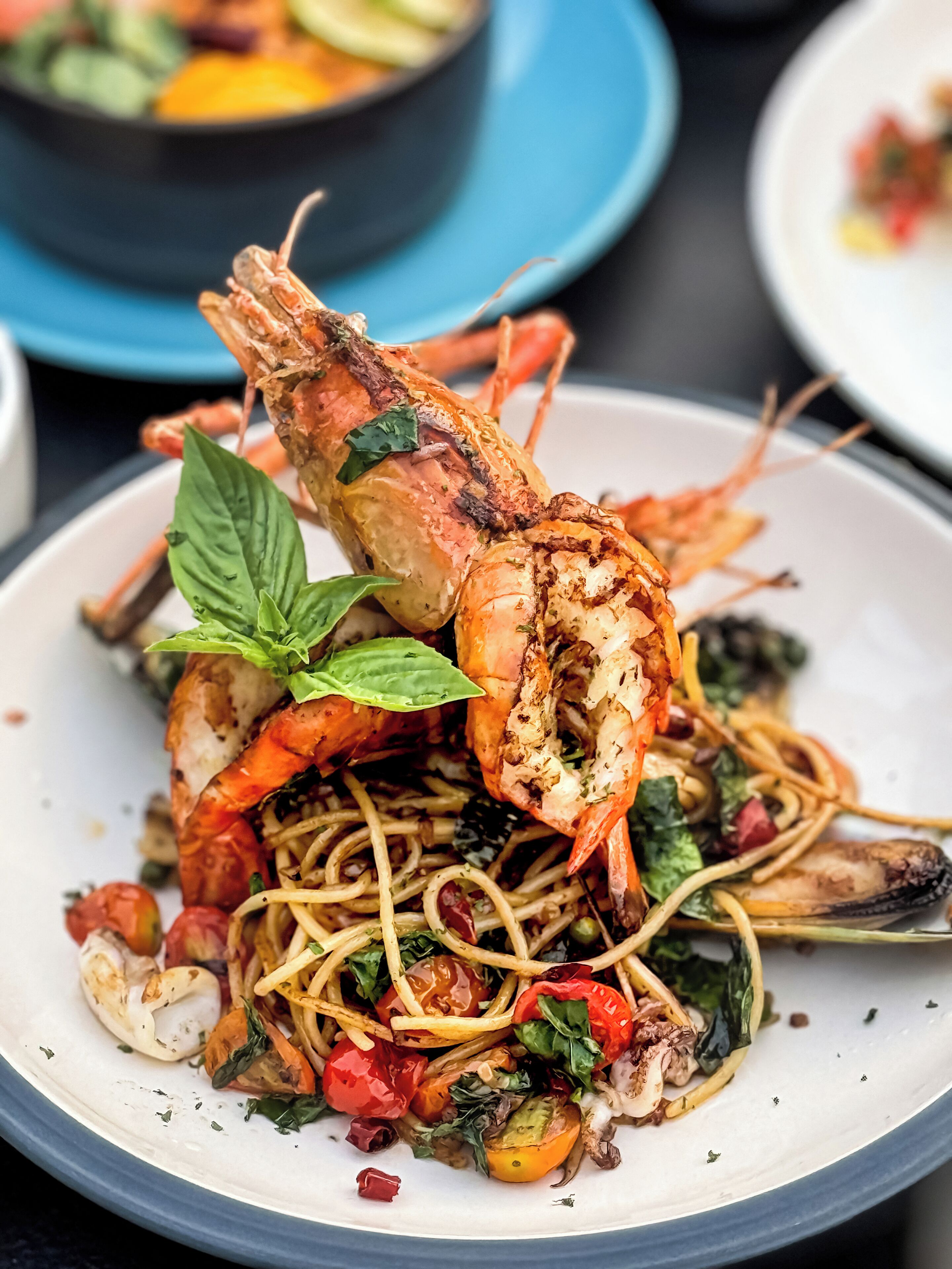 Un plato de espagueti con camarones y verduras.