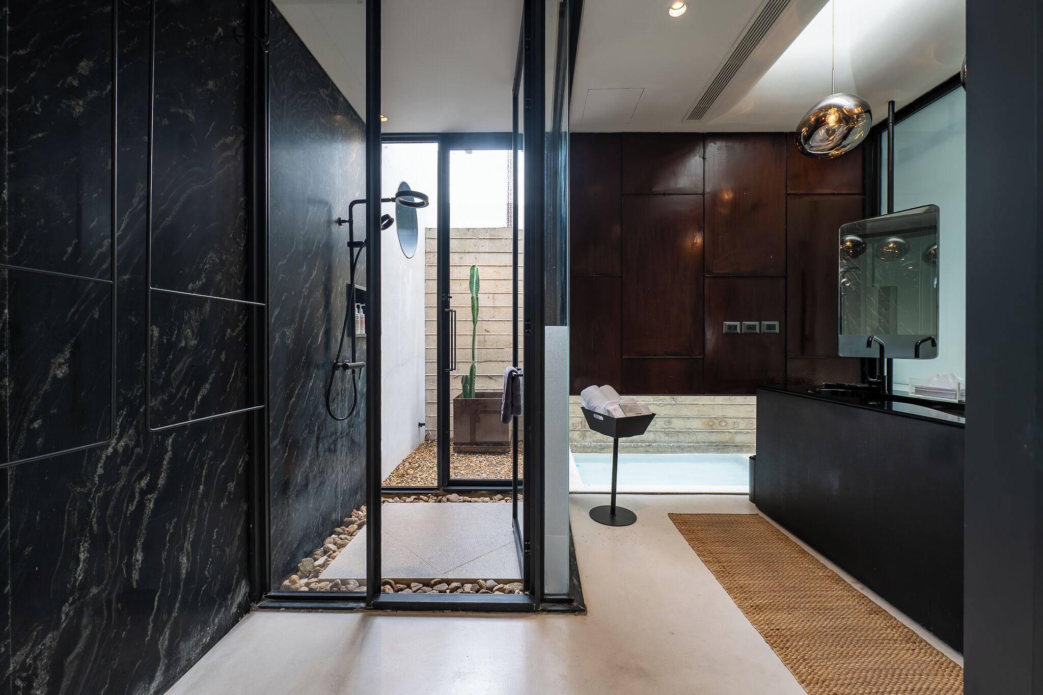 A modern bathroom with a glass shower enclosure, a built-in sink, and a large mirror.
