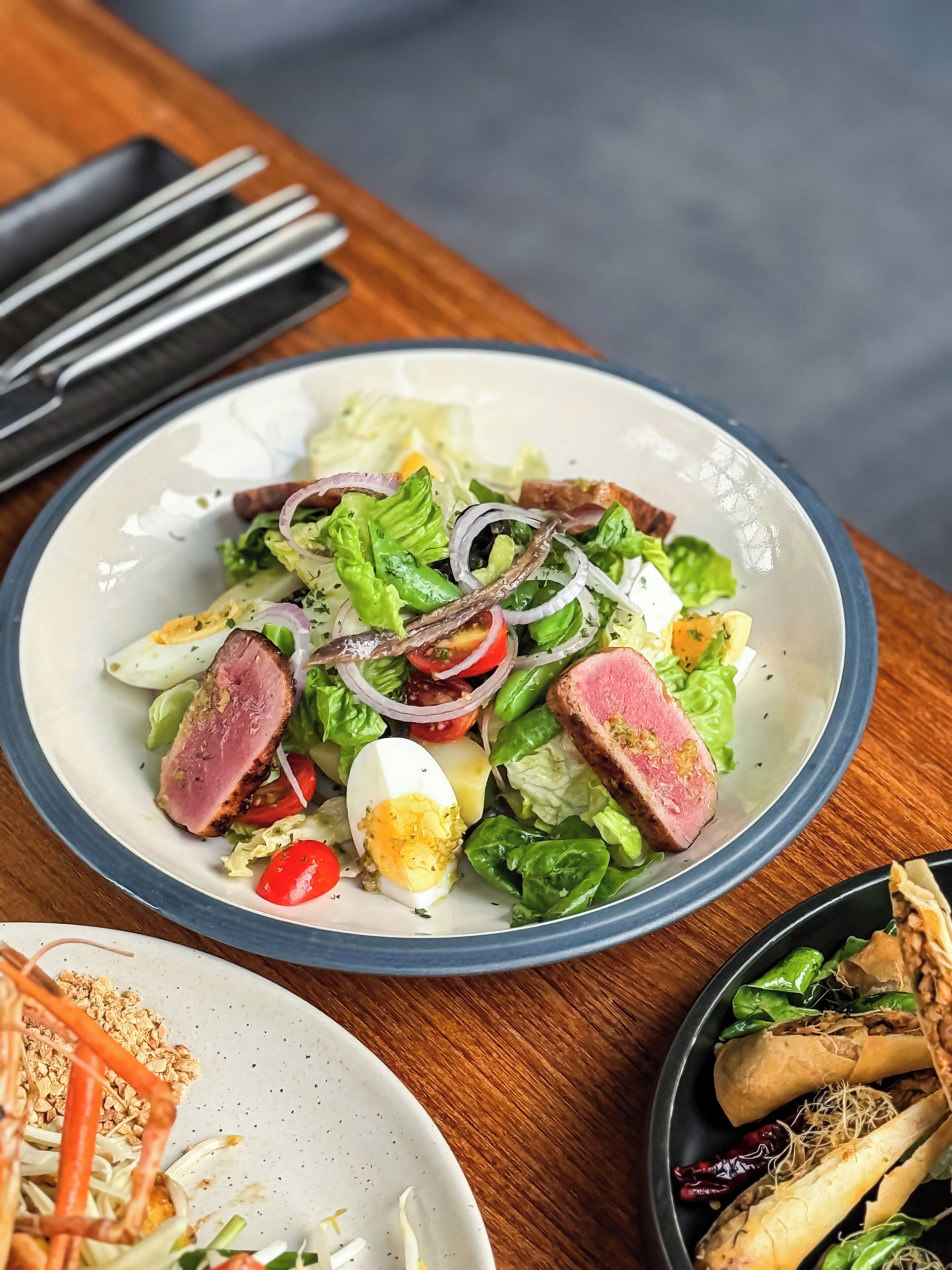 Un plato de comida con ensalada, huevos y carne.