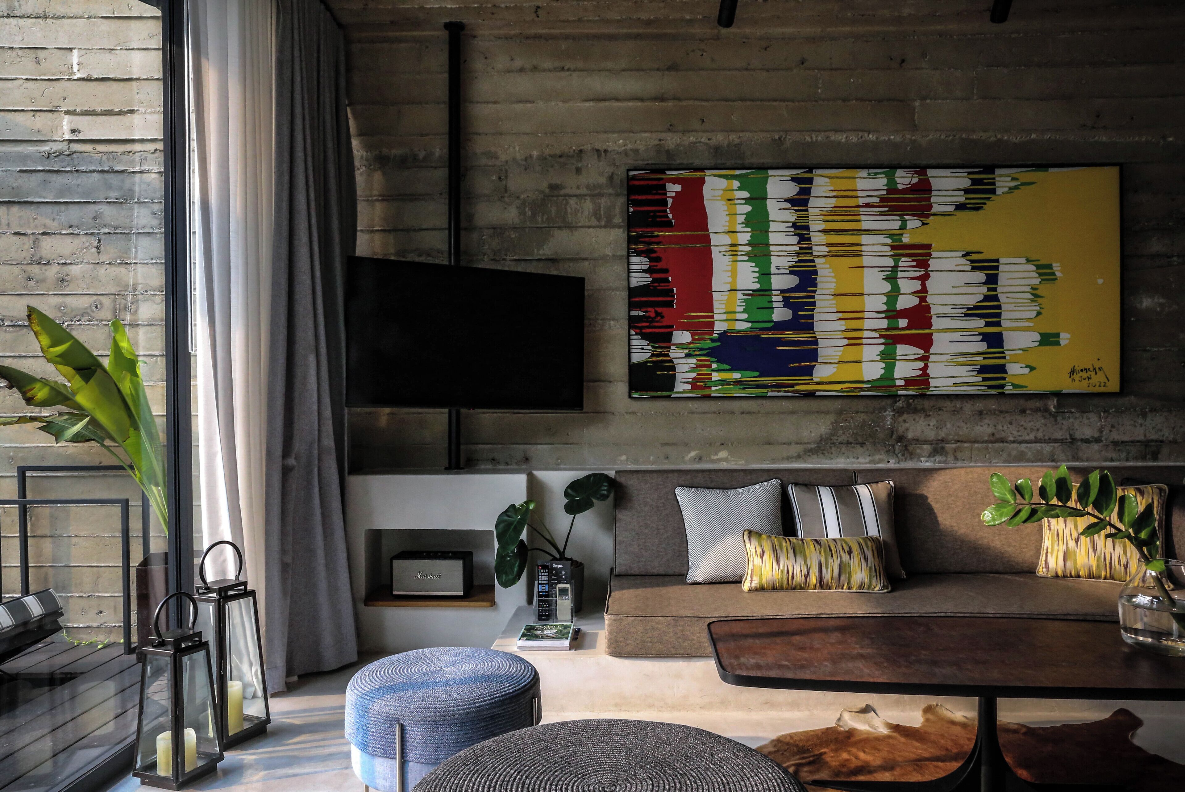 A modern living room with a sofa, a coffee table, and a large abstract painting.