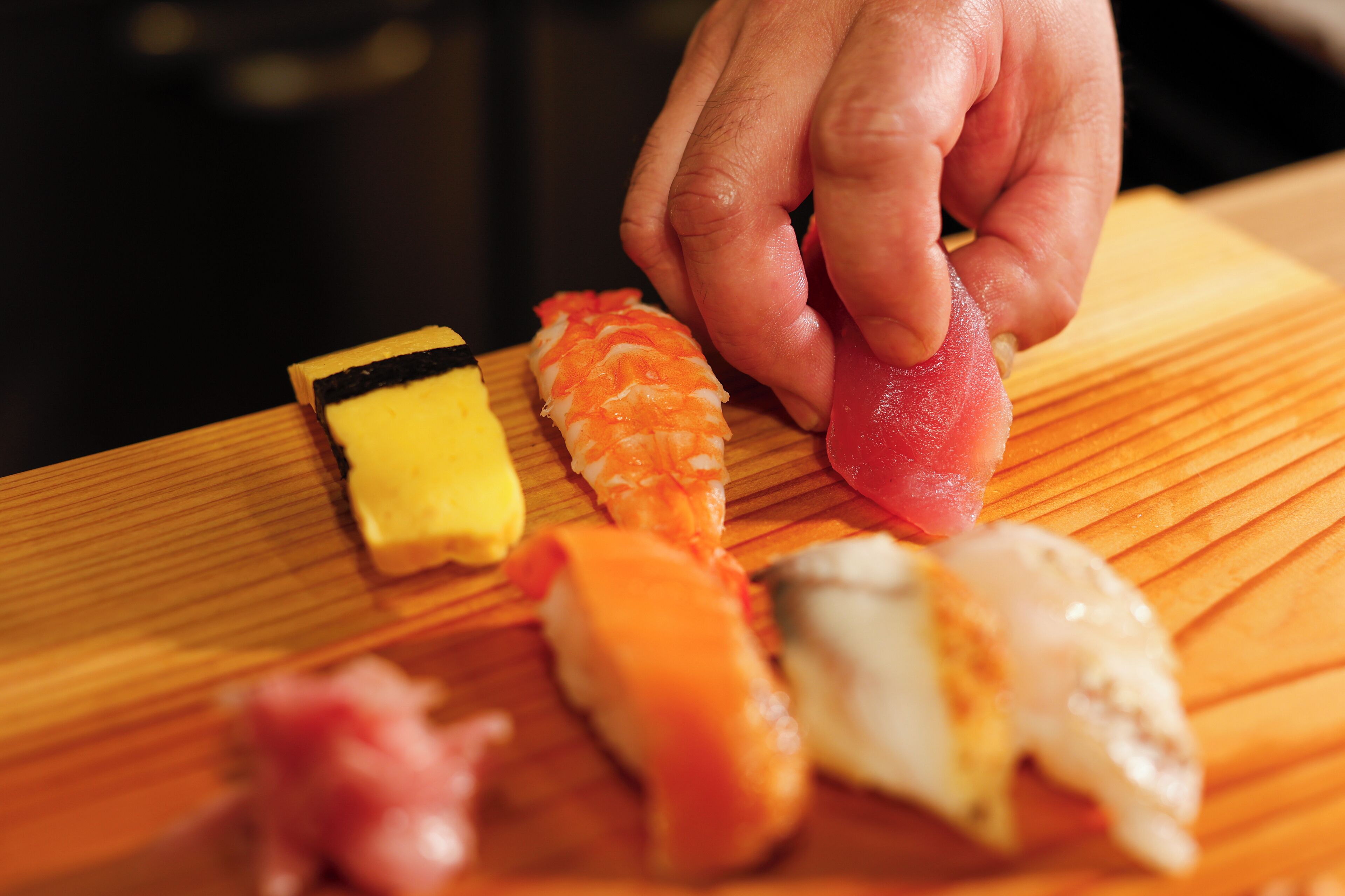 Verschiedene Sushi-Sorten auf einem Holztisch.